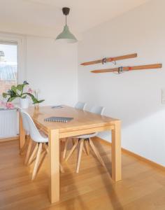 a dining room table with white chairs and a wooden table at Modern & Central Apartments in Luzern