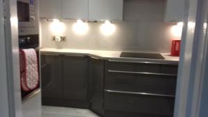 a kitchen with black cabinets and a stove top oven at Highfield Cottage in Kirknewton