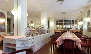 a dining room with a table and chairs and a restaurant at Hotel Liabeny in Madrid