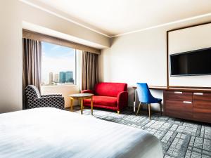 una camera con letto e TV a schermo piatto di Hotel Hanshin Osaka ad Osaka