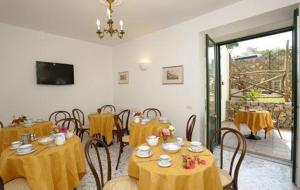 een eetkamer met tafels en stoelen met geel tafelkleed bij Il Ducato Di Ravello in Ravello