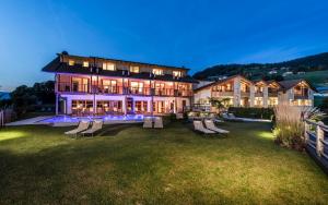 une grande maison avec des chaises dans la cour la nuit dans l'établissement Sonus Alpis - Adults Only, à Castelrotto