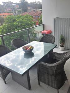 einen Tisch mit einer Obstschale auf dem Balkon in der Unterkunft Modern & Cozy Unit Just Steps from Terrigal Beach in Terrigal