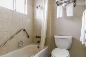 a bathroom with a toilet and a tub and a sink at Quality Inn & Suites Silicon Valley in Santa Clara