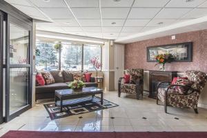 a lobby with a couch and chairs and a table at Econo Lodge in Orillia