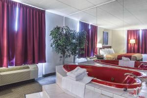 a hotel room with a bath tub and a bed at Econo Lodge in Orillia