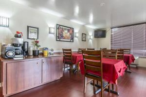 a dining room with a table and chairs and a microwave at Econo Lodge in Orillia