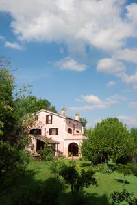 een groot wit gebouw in een veld met bomen bij Agriturismo La Vecchia Quercia in San Cipriano Picentino