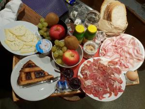 une table recouverte de assiettes de nourriture et de fruits dans l'établissement Agriturismo Rivet d'Or, à Pragelato