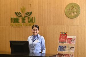 een vrouw aan een tafel met een laptop bij Torre de Cali Plaza Hotel in Cali