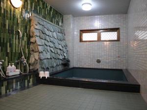 Das Bad ist mit einer Badewanne und einer Dusche ausgestattet. in der Unterkunft Kimatsu Ryokan in Hiroshima