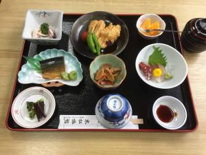 ein Tablett mit Essen auf einem Tisch in der Unterkunft Kimatsu Ryokan in Hiroshima