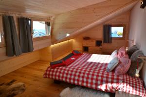 1 dormitorio con 1 cama con manta roja y blanca a cuadros en Chalet Rouge Coeur, en Fenalet Sur Bex