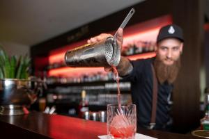 een man maakt een drankje aan een bar bij Hotel Platzhirsch in Fulda