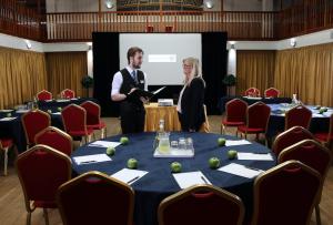 Ein Mann und eine Frau stehen vor einem Bildschirm in einem Konferenzraum in der Unterkunft Royal Maritime Hotel in Portsmouth