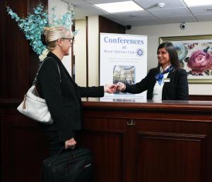 Eine Frau, die Hand schüttelt mit einer Frau hinter einem Schreibtisch in der Unterkunft Royal Maritime Hotel in Portsmouth