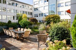 eine Terrasse mit einem Tisch und Stühlen vor einem Gebäude in der Unterkunft Kronenhotel in Stuttgart