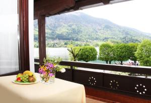 - une table avec une assiette de fruits et une vue sur la montagne dans l'établissement Hotel-Restaurant Stefanihof, à Fuschl am See