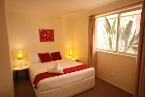 a bedroom with a large bed with a window at Verona Vineyard Cottage in Pokolbin