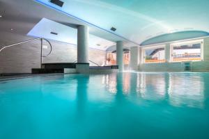 una piscina con illuminazione blu in un edificio di Albergo Alla Rosa a Canazei