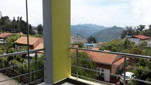 een balkon met uitzicht op de stad bij Swiss Cottage in Kodaikānāl