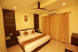 Schlafzimmer mit einem Bett und einem Deckenventilator in der Unterkunft The Crescent Suites in Ernakulam