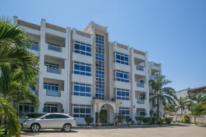 a car parked in front of a building at Almasi Oceanfront Nyali in Mombasa