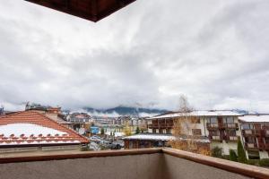 Blick auf eine Stadt mit schneebedeckten Dächern in der Unterkunft Kap House Family Hotel in Bansko