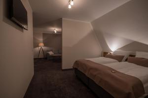 a bedroom with a large bed and a television at Hotel Stadt Aurich in Aurich