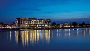 un grande edificio con luci sull'acqua di notte di Bayside a Scharbeutz