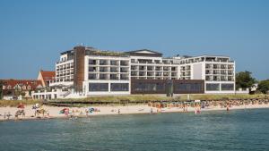 un grande edificio su una spiaggia con persone di Bayside a Scharbeutz