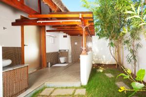 une terrasse avec des toilettes sous une pergola en bois dans l'établissement Le Pondy, à Pondichéry