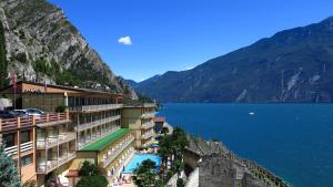 un hotel sul fianco di una montagna vicino a un corpo d'acqua di Hotel Splendid Palace a Limone sul Garda