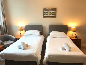 - 2 lits dans une chambre d'hôtel avec des serviettes dans l'établissement Keswick Park Hotel, à Keswick