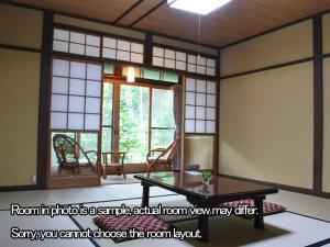 a room with a table and a large window at Kyo no Minshuku Ohara no Sato in Kyoto