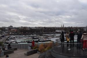 um grupo de pessoas olhando para um porto com barcos em MPS Flora em Amesterdão