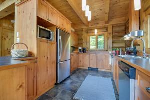 eine Küche mit Holzschränken und einem Kühlschrank in der Unterkunft Log Cabin Home with Lake and Mountain view by Reserver.ca in Sainte-Adèle