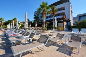 - une rangée de chaises et de parasols sur une plage dans l'établissement Hotel Jona, à Podstrana