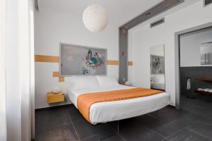 een slaapkamer met een groot bed en een oranje deken bij nautilus b&b suite design in Follonica