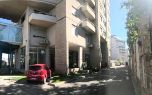 un coche rojo estacionado frente a un edificio en Jardines de Belgrano, en Salta