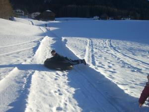 a man laying in the snow on a snowboard at Kompatscherhof in Castelrotto