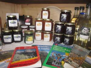 a table topped with jars of jam next to books at Kompatscherhof in Castelrotto