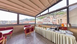 un ristorante con tavolo, sedie e ampie finestre di Old Meidan Tbilisi By Urban Hotels a Tbilisi City