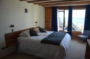 1 dormitorio con cama y ventana grande en Puerto Austral, en Puerto Varas