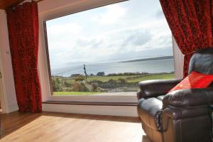 Ard na Carraige, Ventry Holiday Home في دينغل: غرفة معيشة مع أريكة ونافذة كبيرة