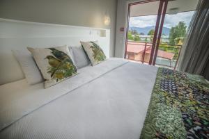 una camera da letto con un grande letto bianco e una finestra di Red Tussock Motel a Te Anau