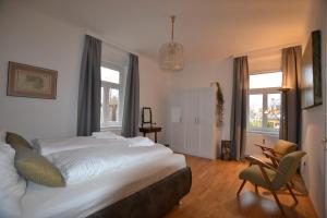 Apartment Graz-Ulrichsbrunn, free parking في غراتس: غرفة نوم بسرير وكرسي ونوافذ