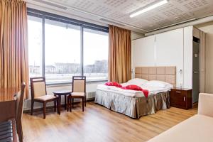 a bedroom with a bed and a table and chairs at Hotel Citi Inn in Tampere