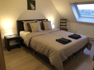 a bedroom with a large bed with two towels on it at Maaszicht in Maasmechelen