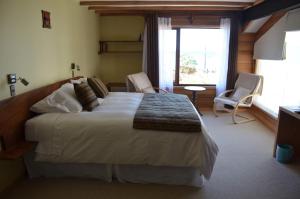 1 dormitorio con cama grande y ventana grande en Puerto Austral, en Puerto Varas